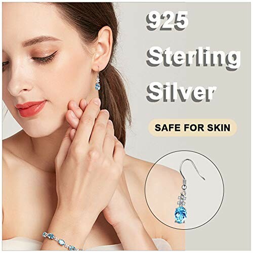 Woman wearing 925 sterling silver jewelry with blue gemstones.